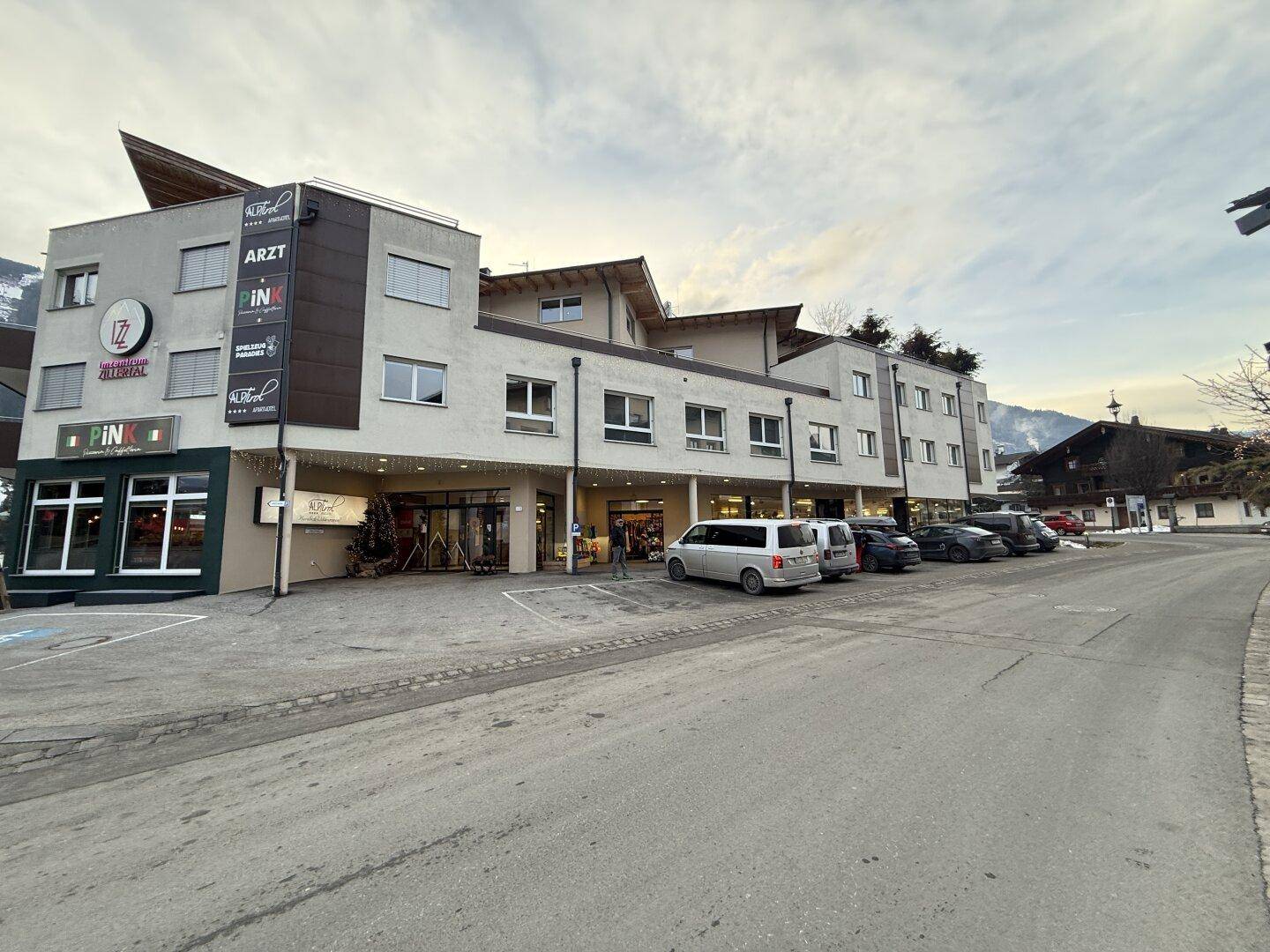 Gesamtansicht Geschäftslokal Kaltenbach mit Geschäftsgebäude, Parkflächen und Zillertaler Berglage